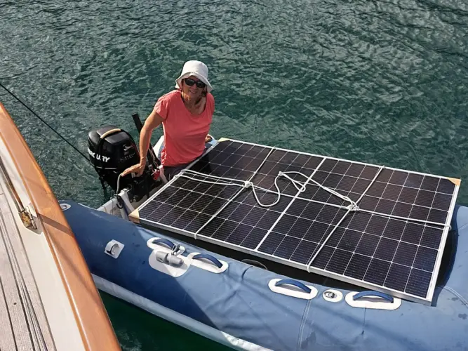 Shows transportation of solar panel by dinghy.